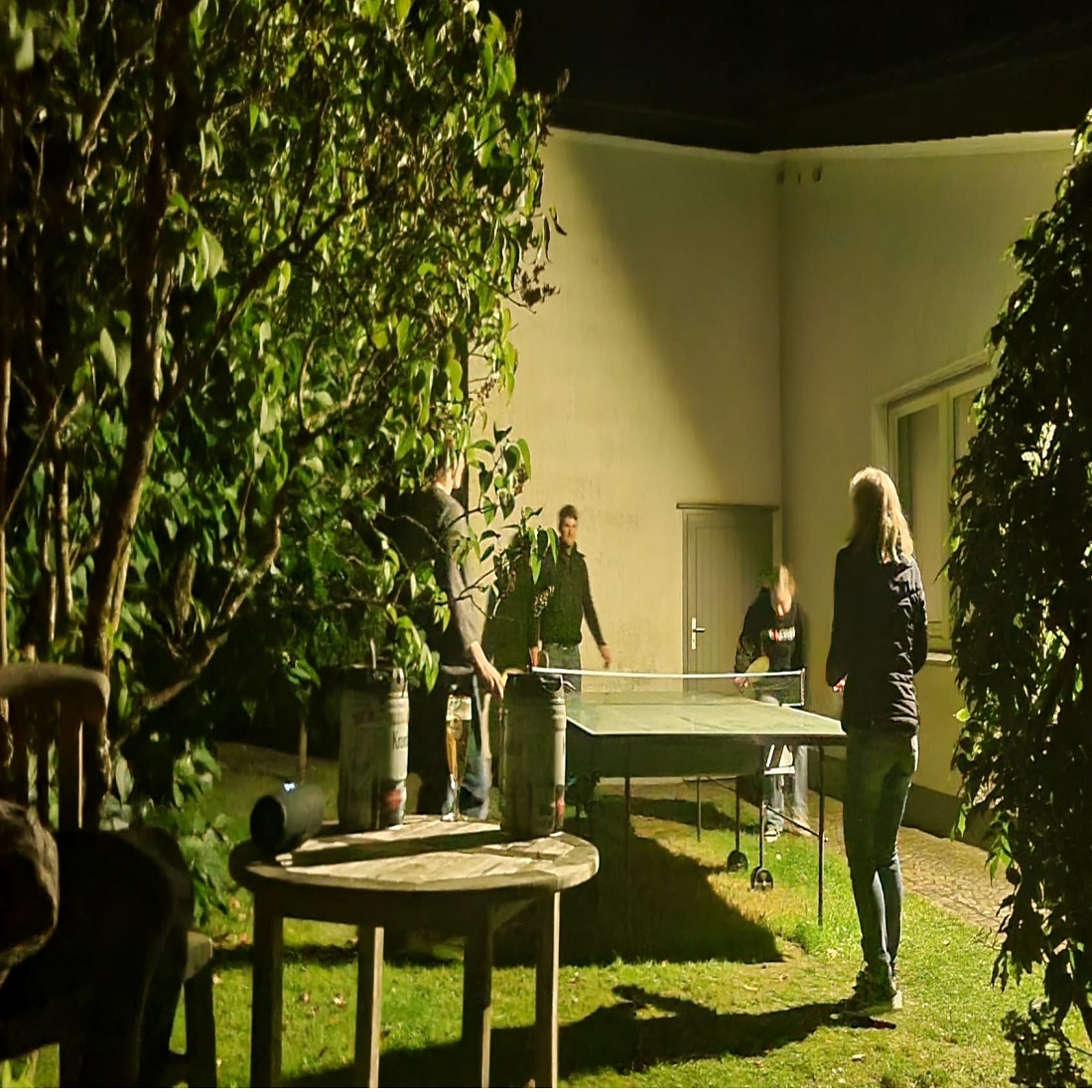 Menschen spielen an einer Platte Tischtennis