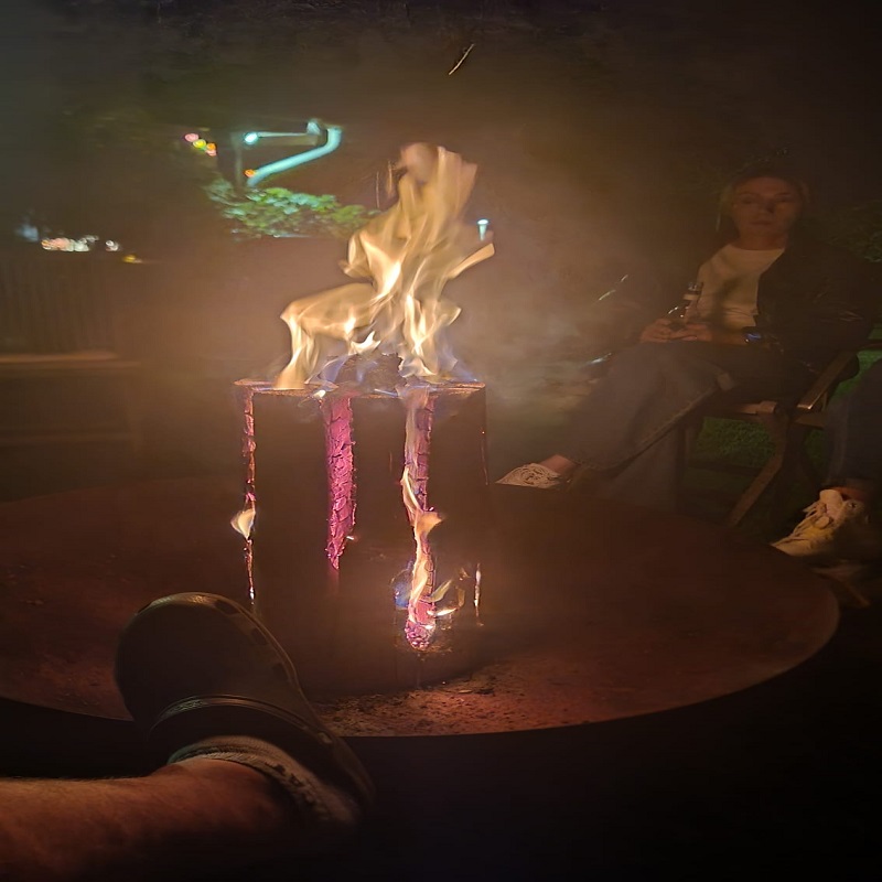 Menschen sitzen um Feuertonne