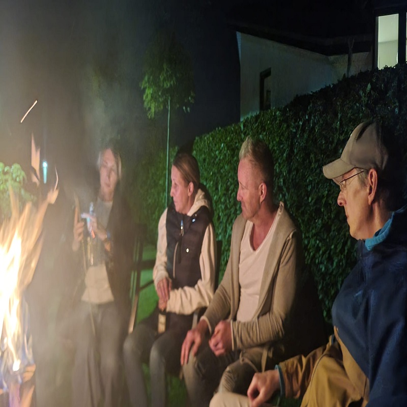 Menschen sitzen an Feuertonne